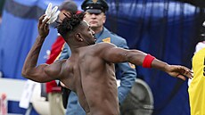 Nasupený wide receiver Antonio Brown z Tampa Bay hází svou výstroj divákm a...