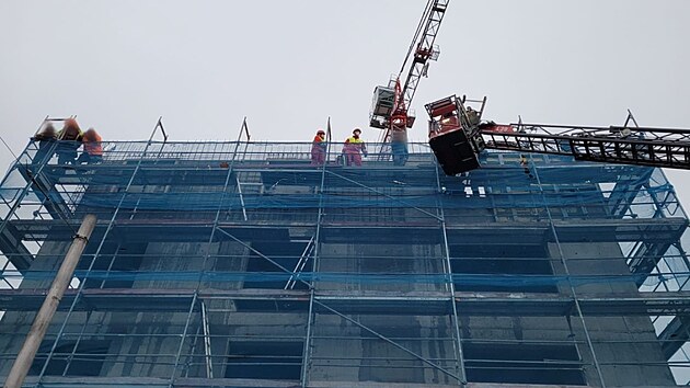 Záchranáři ošetřili dělníka v pátém patře ešení novostavby ve Střelecké ulici v Hradci Králové, dolů ho spustili hasiči (17. 1. 2022).