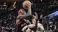 Pascal Siakam z Toronta se prosazuje pes Graysona Allena z Milwaukee.