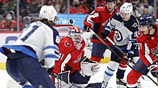 Branká� Washingtonu Vítek Van��ek pod tlakem hokejist� Winnipegu.