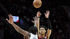 Anfernee Simons (vpravo) z Portlandu stílí pes bránícího Day'Rona Sharpa z...