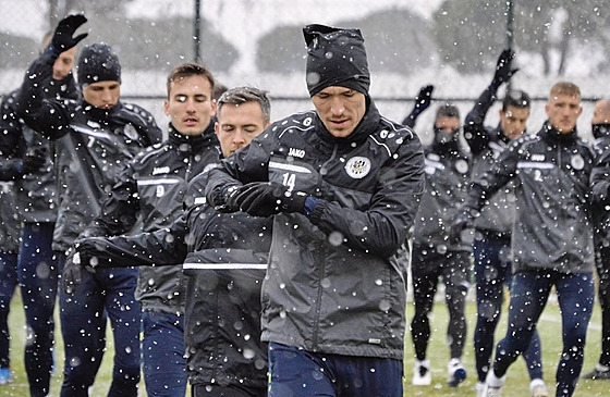 Fotbalisté Hradce Králové se na tréninku v Turecku rozcviují za pomrn...