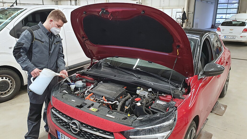 Servisní technik TUkas Auto Staiger pi dolévání ostikovací kapaliny do elektrického Opelu