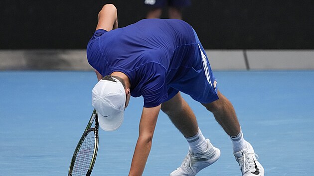 Vyčerpaný Jakub Menšík se snaží překonat křeče ve finále juniorky Australian Open.