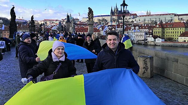 Ukrajinský velvyslanec v Česku Jevhen Perebyjnis s vlajkou Ukrajiny na pražském Karlově mostě