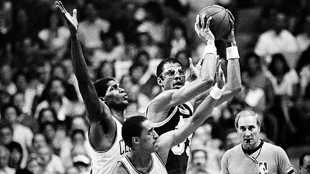 Kareem Abdul-Jabbar z Los Angeles Lakers kontroluje v sedmém finále NBA 1984 míč, atakují ho Robert Parish (vlevo) a Dennis Johnson z Boston Celtics. Hru sleduje rozhodčí Darell Garretson (12. června 1984).