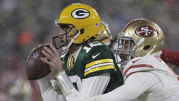 Aaron Rodgers (vlevo) z Green Bay Packers ubrnn v zpase se San Francisco 49ers, stahuje ho Arik Armstead.