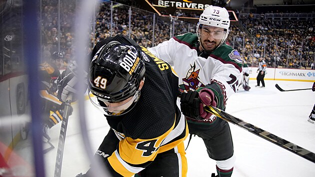 Dominik Simon (49) z Pittsburgh Penguins bojuje u mantinelu s Kylem Capobiancem z Arizona Coyotes.