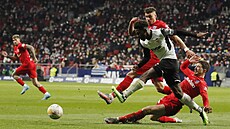 Yunus Musah z Valencie prohání soupe�e z Atlétika Madrid. Skluzem brání �ime...