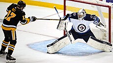 Gólman Winnipegu Connor Hellebuyck (vpravo) zasahuje proti anci Bryana Rusta z...