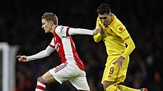 Martin Odegaard (vlevo) z Arsenalu uniká Robertu Firminovi z Liverpoolu.