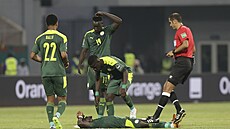 Senegalský kapitán Sadio Mané na zemi, k ostesené opoe se sklánjí spoluhrái.