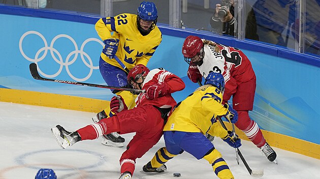 Dnka Josefine Perssonov vpedu vlevo, bojuje o puk se vdkou Ebbou Berglundovou (8) bhem pedkola enskho hokejovho utkn. (8.nora 2022)