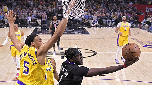 Reggie Jackson z Los Angeles Clippers zakonuje, pod koem ho brn Talen Horton-Tucker z Los Angeles Lakers.