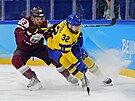 Lotyský útoník Deniss Smirnovs se hokejkou opírá do zad Lukase Bengtssona ze...