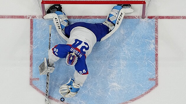 Slovenský hokejový brankář Patrik Rybár skáče pro další kotouč v olympijském semifinále.