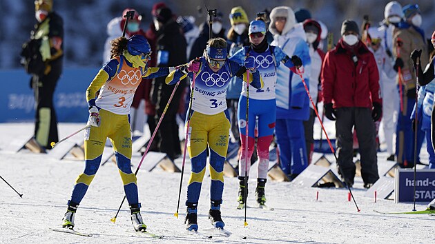 Biatlonistky bojuj ve tafetovm zvod na zimnch olympijskch hrch v Pekingu na ZOH 2022. Hanna Oebergov ze vdska, vlevo, pedv tafetu na Elviru Oebergovou. (16. nora 2022)