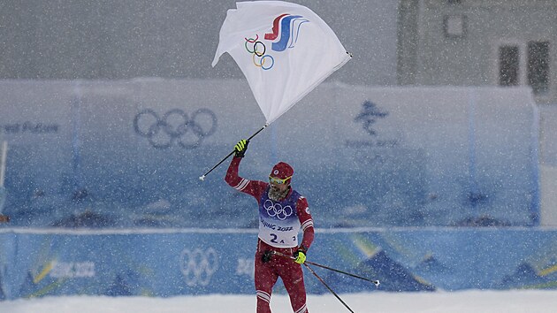 Sergej Usugov finiuje s vlajkou Ruskho olympijskho vboru.