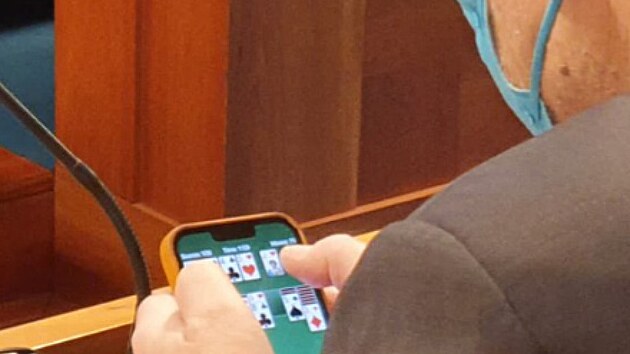 Ministr zdravotnictví Vlastimil Válek hraje na mobilu karty bhem jednání...