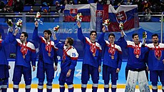 Slovenští hokejisté oslavují zisk bronzových medailí na hrách v Pekingu.