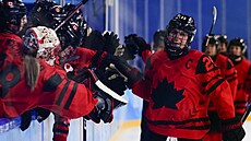 Marie-Philip Poulinová si plácá se svými kanadskými spoluhrá�kami poté, co...