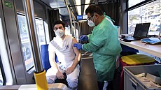 Lékař očkuje zaměstnance MKT Krankentransport OHG v mobilní očkovací stanici na...
