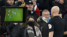 Rozhod�í Anthony Taylor sleduje monitor a obrázky, které mu v zápase Premier...