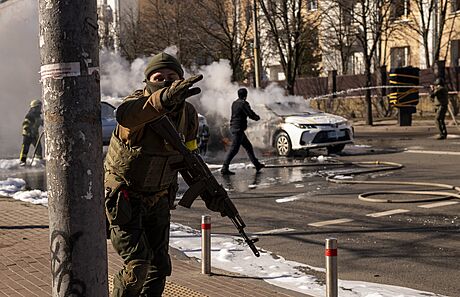 Ukrajintí vojáci v centru Kyjeva hasí auta, která zaala po dopadu ruských...