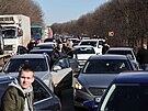 Lidé ekají v dopravní zácp, kdy opoutjí msto Charkov. (24. února 2022)