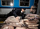 Policisté nakládají pikrývky do vlak, smujících k ukrajinské hranici