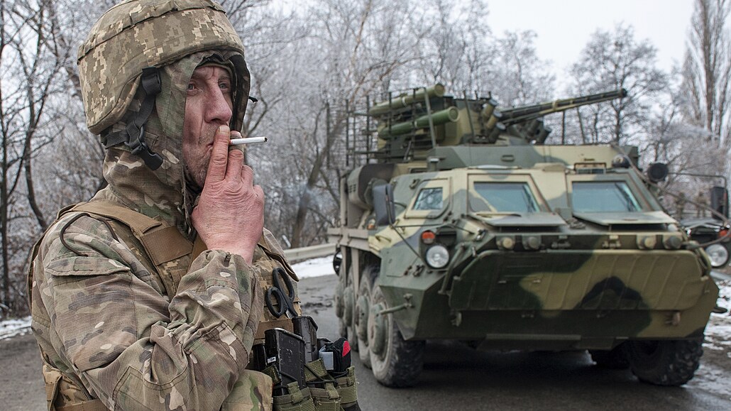 Ukrajinský voják kouí cigaretu na svém stanoviti u obrnného vozidla u...