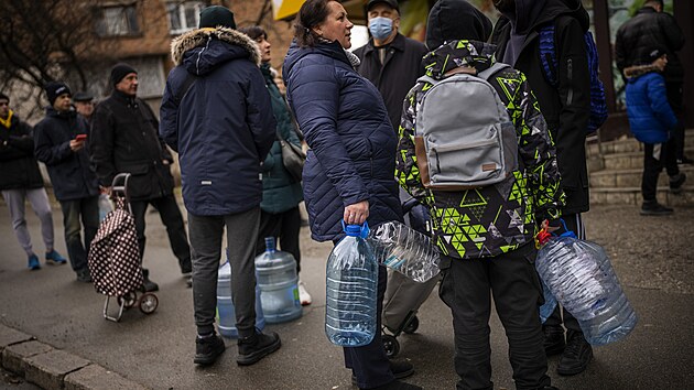 Obyvatel ekaj v Kyjev na natoen vody pot, co v nkterch stech msta pestala tct voda. (24. nora 2022)