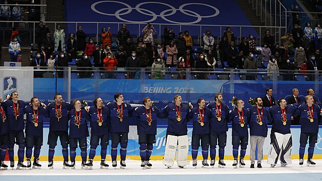Fint hokejist si bhem ceremonilu po vtzstv v olympijskm finle s medailemi na krku zpvaj nrodn hymnu