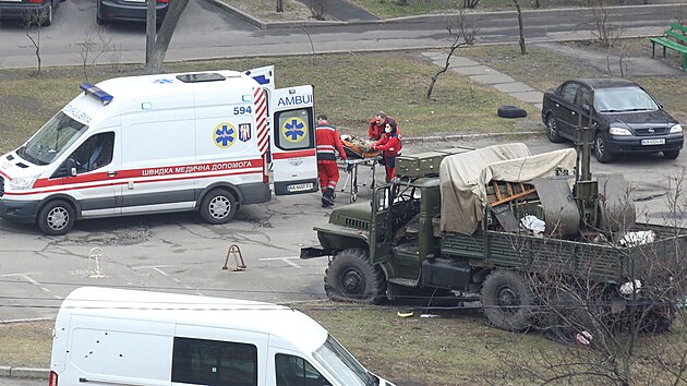 Zdravotnci pevej zrannho vojka v obytn tvrti v Kyjev. (25. nora 2022)