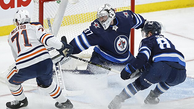 Kristian Reichel (87) z Winnipegu pom�h� sv�mu brank��i Connoru Hellebuyckovi (37) proti Ryanu McLeodovi (71) z Edmontonu.