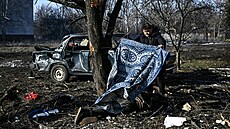 Muž zakrývá tělo oběti, jenž přišla o život při bombových útocích na město... | na serveru Lidovky.cz | aktuální zprávy
