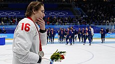 Zklamaný ruský útoník Plotnikov (16) se stíbrnou medailí. V pozadí slavící...
