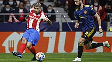 Ángel Corea (Atlético) posílá balon pry ped dobíhajícím Brunem Fernandesem...