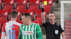 Sudí Jan Machálek ud�luje �lutou kartu v utkání Slavia - Bohemians.