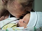 Ukrajinská ena líbá svého novorozeného syna ve sklep porodnice v Mariupolu,...