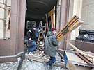 Lidé odklízejí trosky ped budovou regionální správy v Charkov, která byla...