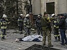 Ukrajintí záchranái stojí kolem tla obti ruského ostelování Charkova. (1....