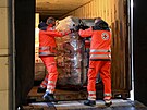 Zamstnanci nmeckého erveného kíe nakládají auto balíky s humanitární...