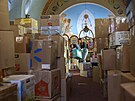 Dobrovolníci tídí krabice s humanitárními dary pro Ukrajinu v kostele sv....