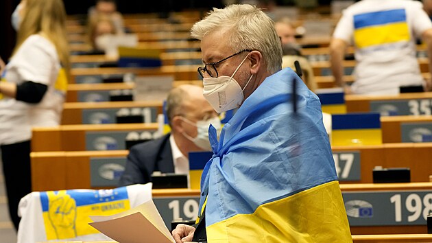 Člen Evropského parlamentu symbolicky zahalený do ukrajinské vlajky na mimořádném zasedání k otázce ruské invaze na Ukrajině (1. března 2022)