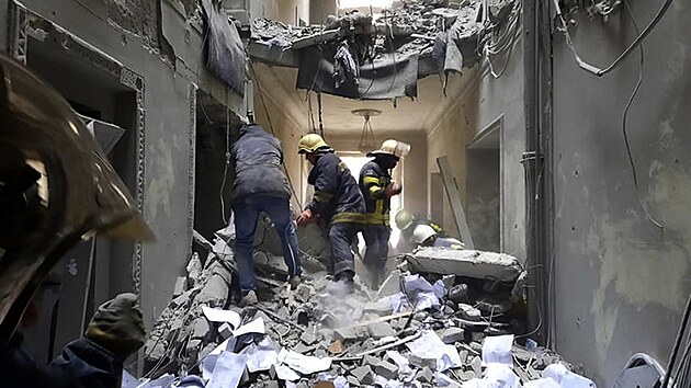 Pracovníci záchranné služby kontrolují poškození uvnitř budovy radnice v Charkově na Ukrajině. (1. března 2022)