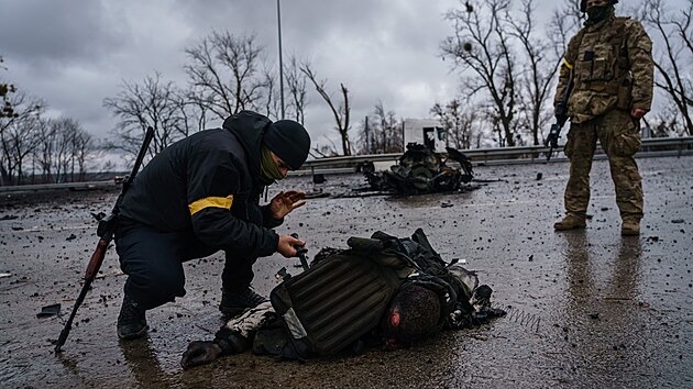 Ukrajint vojci zachrauj vybaven z tla mrtvho ruskho vojka, kter zemel v bitv u hlavn silnice ve mst Sytnyaky na Ukrajin. (1. bezna 2022)