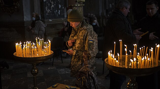 Ukrajinská vojačka se modlí v kostele svatých Petra a Pavla ve Lvově. (6. března 2022)