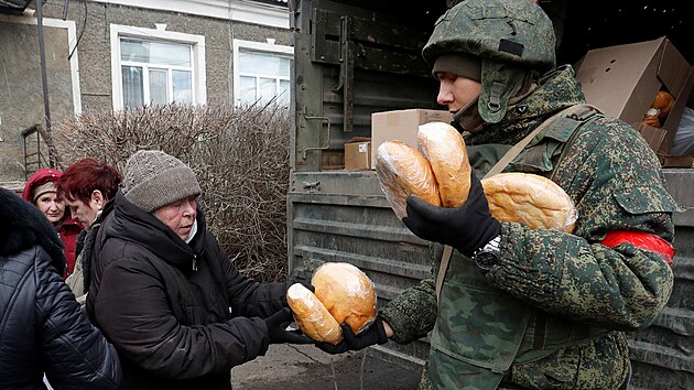 Vojk proruskch jednotek rozdv chleba obyvatelm vesnice Bugas. (6. bezna 2022)