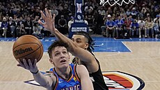 Vít Krej�í z týmu Oklahoma City zakon�uje p�es bránícího Jordana Nworu z...